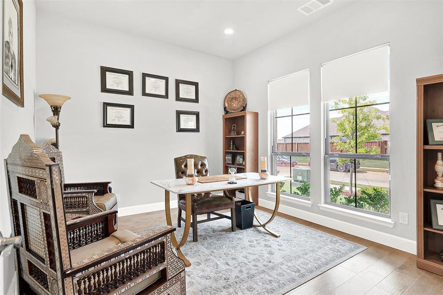 Office area with light wood-style flooring and recessed lighting