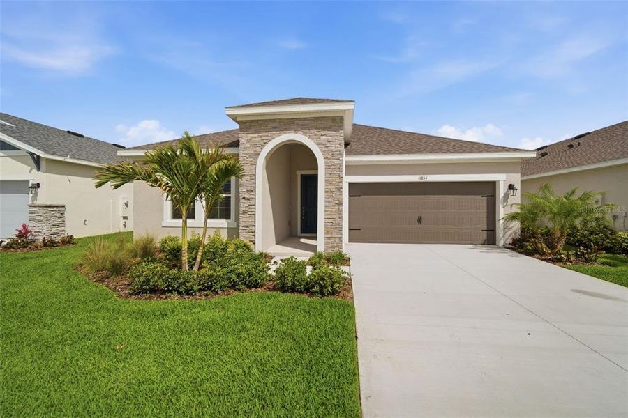 Front exterior of a new home in North River Ranch, Parrish, FL, highlighting curb appeal (Image 21).
