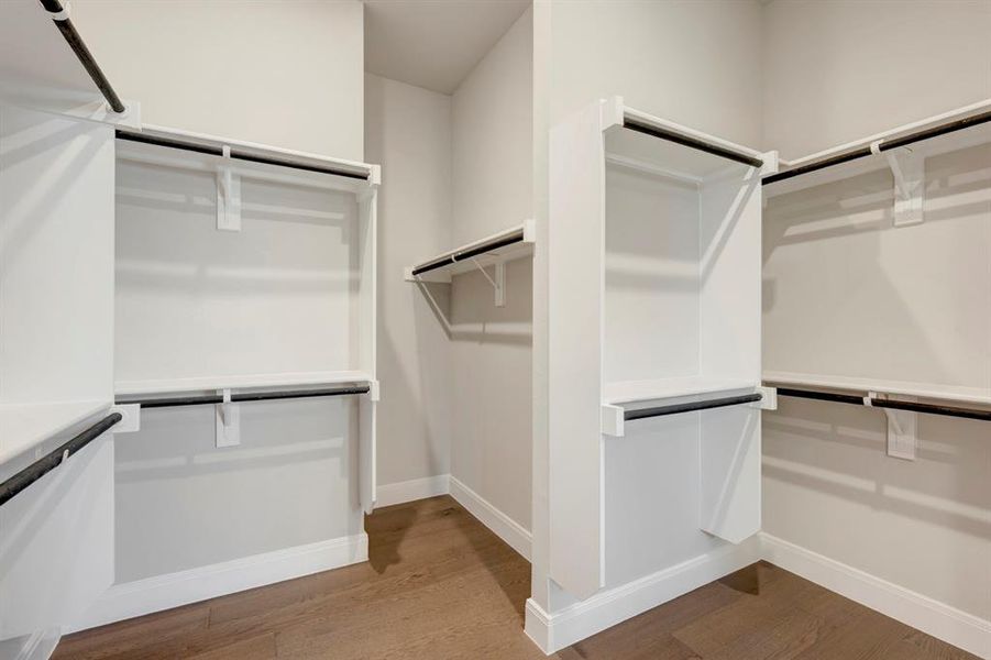 Walk in closet with light wood-style flooring Walk in closet with light wood-style flooring
