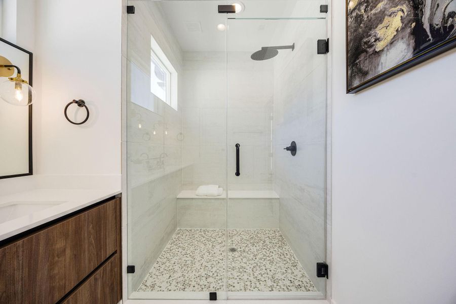 Oversized glass enclosed walk-in shower located in the primary bathroom