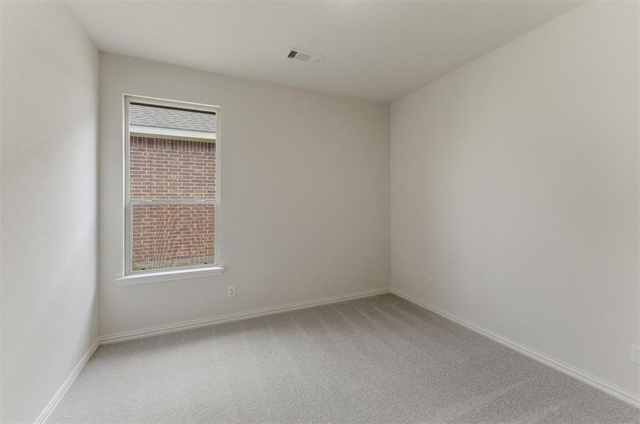 Bright interior room featuring a single window, light gray carpeting, and neutral-toned wall paint