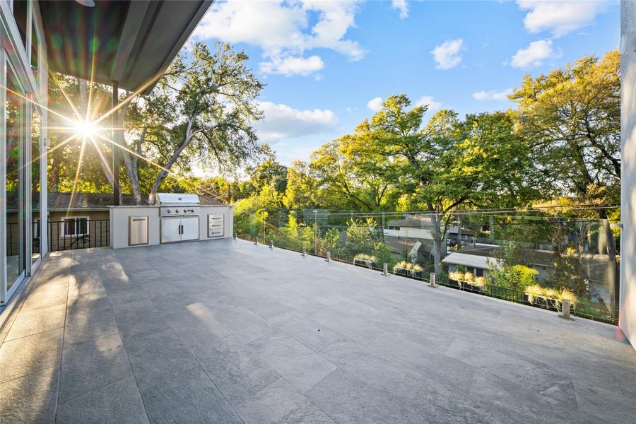 Main level patio with outdoor kitchen and glass railing