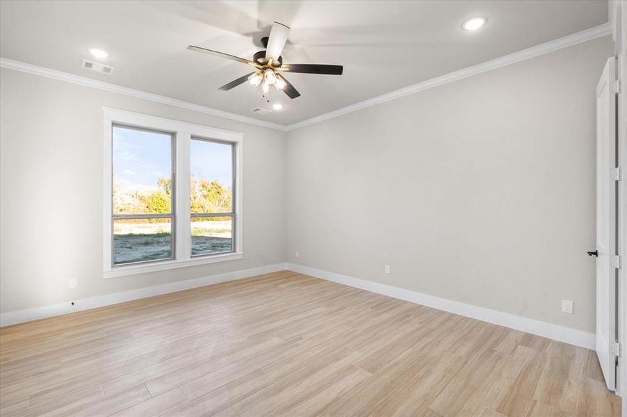 Unfurnished room with ceiling fan, light wood-type flooring, and crown molding