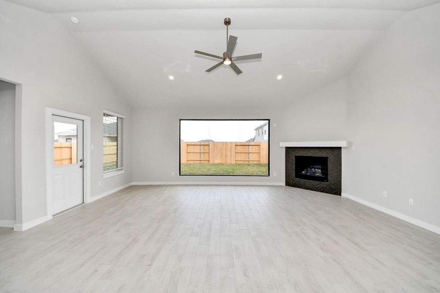Gather the family and guests together in your lovely living room! Featuring soaring high ceilings, recessed lighting, ceiling fan, custom paint, gorgeous floors, and large windows that provide plenty of natural lighting throughout the day.