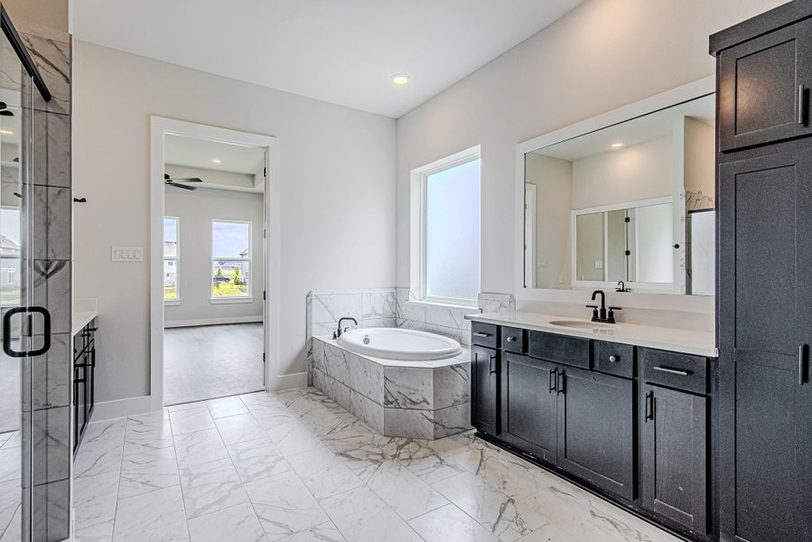 Primary bathroom featuring a separate tub and walk-in shower Primary bathroom featuring a separate tub and walk-in shower