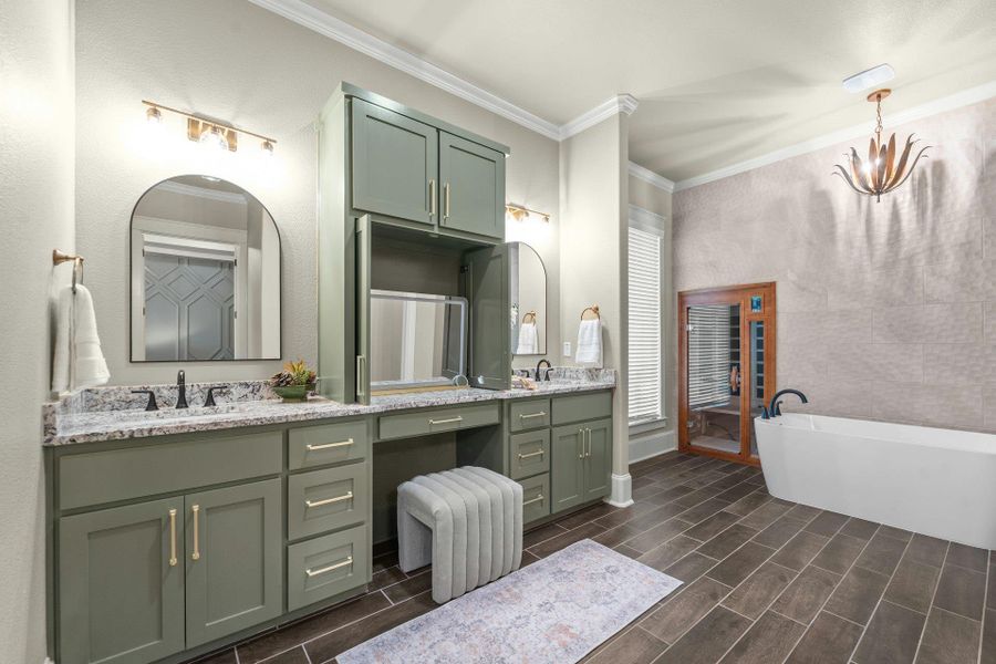 Dual vanity featuring sage green cabinetry, granite countertops, and arched mirrors