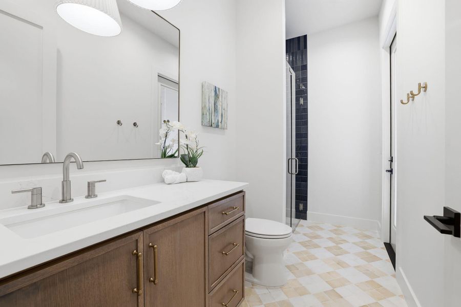 Bathroom with vanity, a shower stall, and light flooring