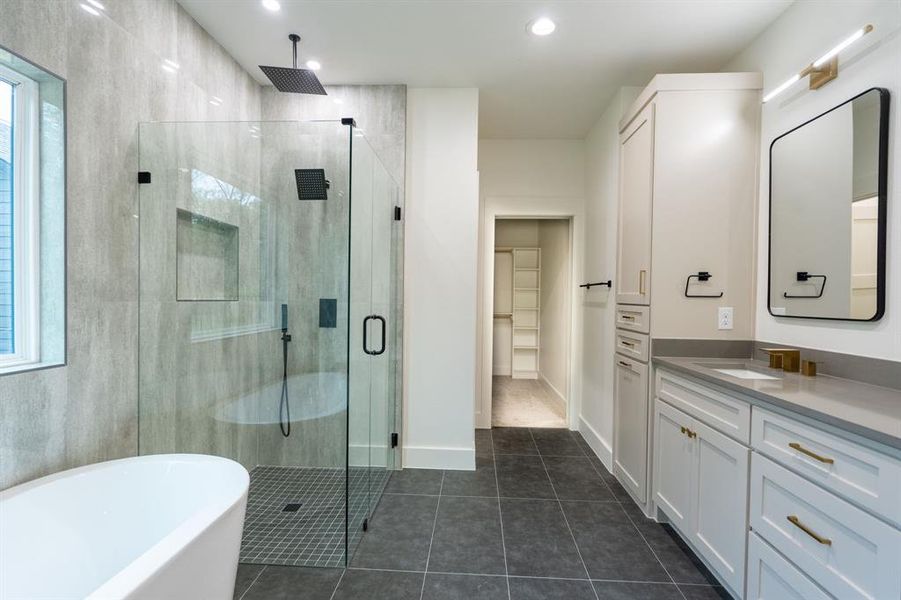 Bathroom featuring vanity, plus walk in shower, a wealth of natural light, and tile patterned floors