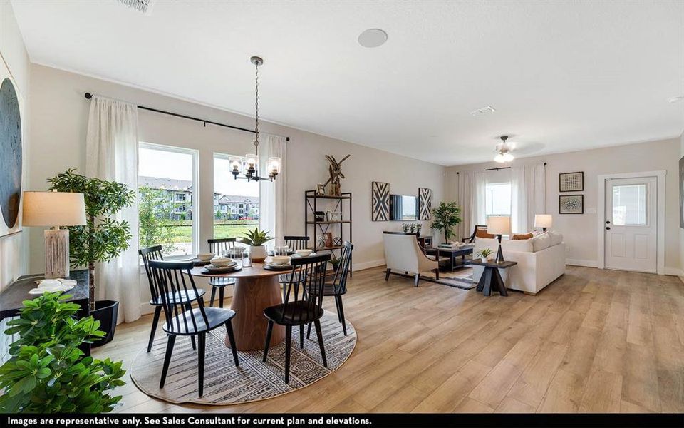 Open-concept living area with wood-finish flooring, recessed lighting, and ample natural light from multiple windows