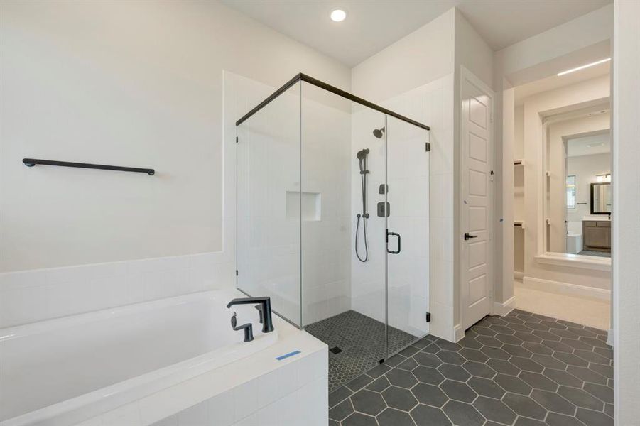 Full bath featuring a bath, a stall shower, dark tile patterned flooring, and recessed lighting