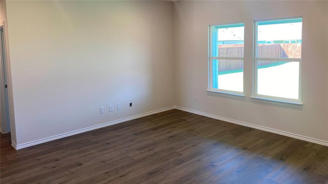 Unfurnished room featuring dark wood finished floors and baseboards