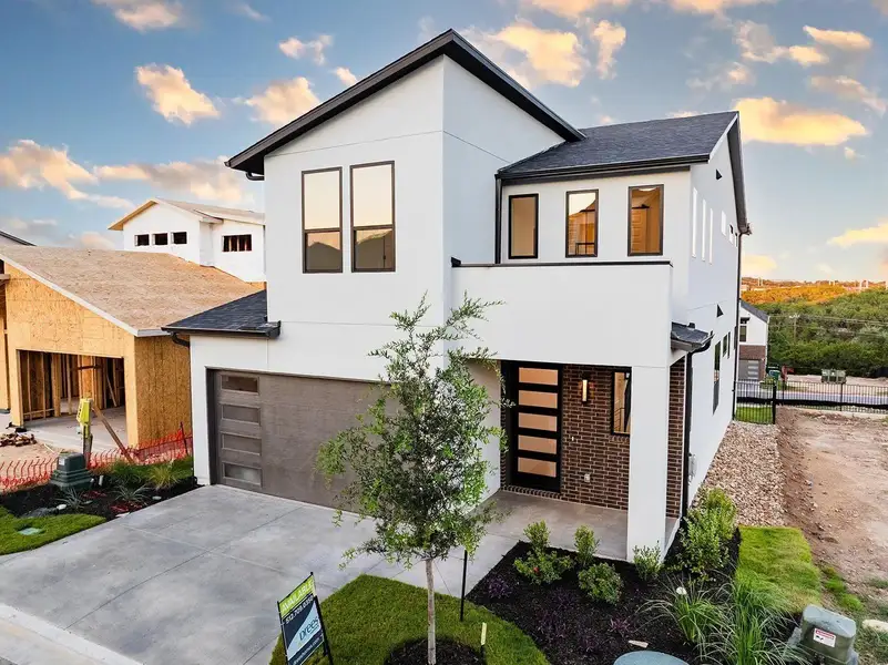 Front exterior of a new home in Rough Hollow The District, Lakeway, TX, highlighting curb appeal (Image 9). Front exterior of a new home in Rough Hollow The District, Lakeway, TX, highlighting curb appeal (Image 9).