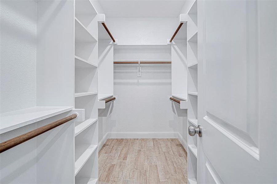 Spacious closet featuring light wood-type flooring Spacious closet featuring light wood-type flooring