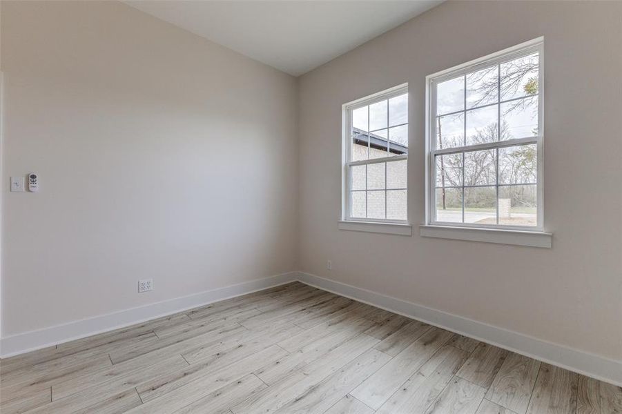 Empty room with baseboards and light wood-style flooring