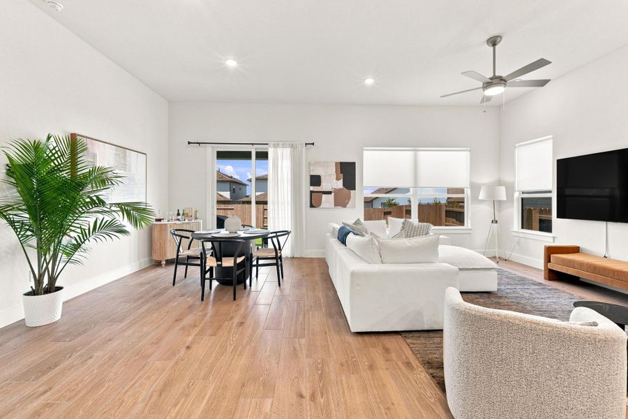 Light-filled family room highlighting expansive windows, an upgraded 6'x8' vinyl sliding glass door, and Level 6 wood-look tile flooring. Light-filled family room highlighting expansive windows, an upgraded 6'x8' vinyl sliding glass door, and Level 6 wood-look tile flooring.