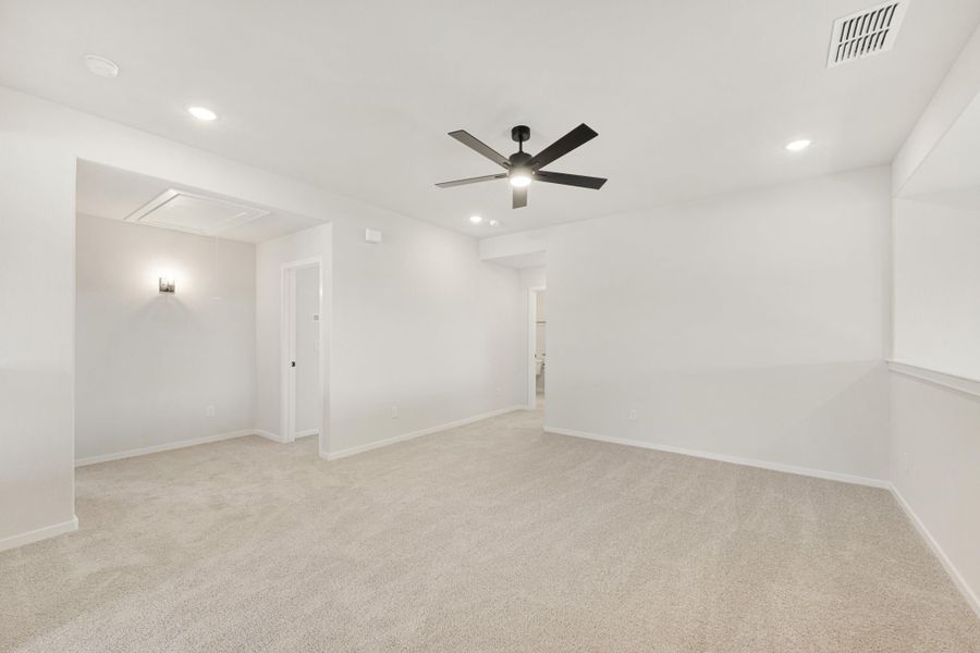 Empty bedroom with beige carpet, white walls, black ceiling fan, and recessed lighting Empty bedroom with beige carpet, white walls, black ceiling fan, and recessed lighting