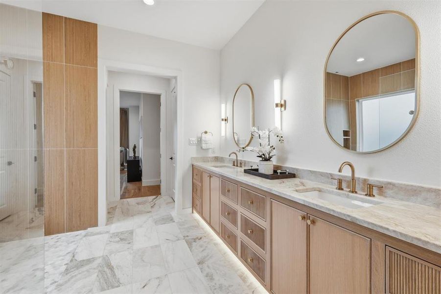 Bathroom featuring double vanity, recessed lighting, and light marble finish flooring