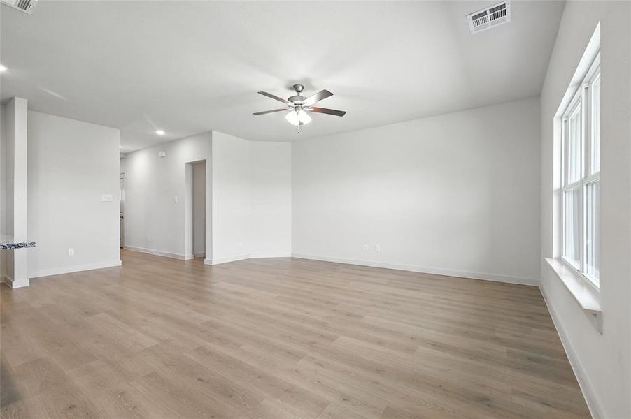 Empty room with ceiling fan, light wood finished floors, and recessed lighting