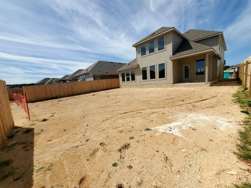 Back of house with a patio, roof with shingles, and a fenced backyard