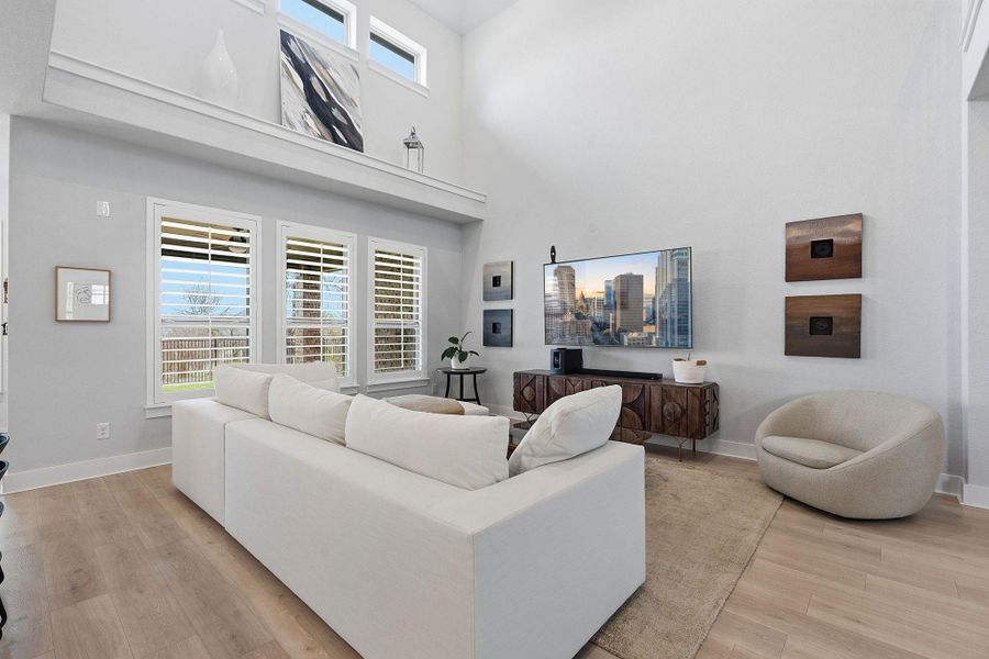 Living room with light wood-style flooring and a high ceiling