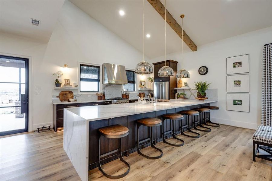 Kitchen featuring pendant lighting, a large island, light hardwood / wood-style floors, and a kitchen breakfast bar