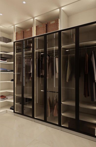 View from a different angle of the primary closet .The room's sophistication is enhanced by the tinted glass doors.