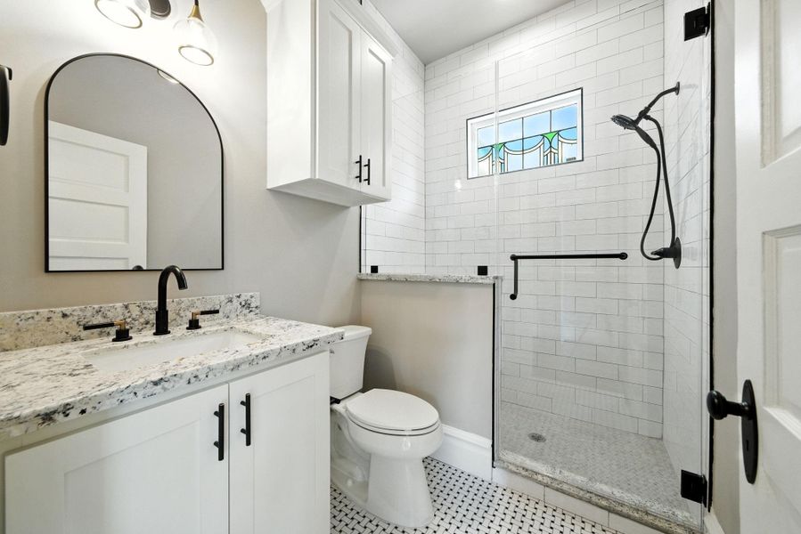 Stand up shower in the first floor ensuite. Custom cabinets and granite counters continue. Note the beautiful stained glass window - letting natural light in, but maintaining privacy! Stand up shower in the first floor ensuite. Custom cabinets and granite counters continue. Note the beautiful stained glass window - letting natural light in, but maintaining privacy!