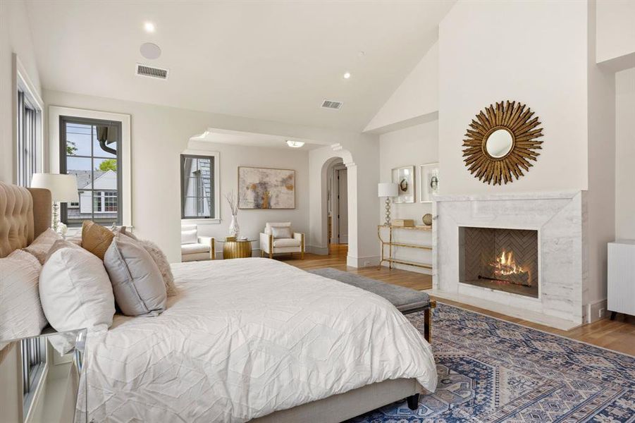 Spacious room featuring a vaulted ceiling and a fireplace with a stone surround Spacious room featuring a vaulted ceiling and a fireplace with a stone surround