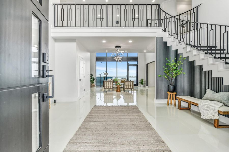 First impressions come with a direct view of the bay. Soaring 20-foot ceilings, a statement staircase and walls of glass introduce the scale, light and architectural drama found throughout the home. First impressions come with a direct view of the bay. Soaring 20-foot ceilings, a statement staircase and walls of glass introduce the scale, light and architectural drama found throughout the home.