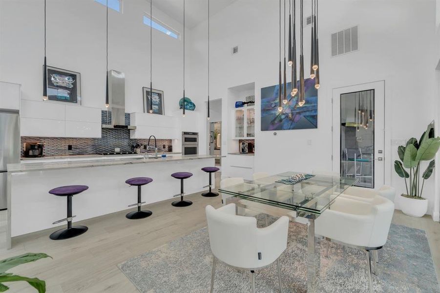 Dining area featuring a high ceiling and light wood finished floors
