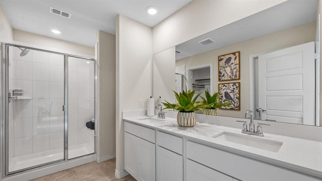 Bathroom featuring double vanity, a stall shower, and light tile patterned floors Bathroom featuring double vanity, a stall shower, and light tile patterned floors