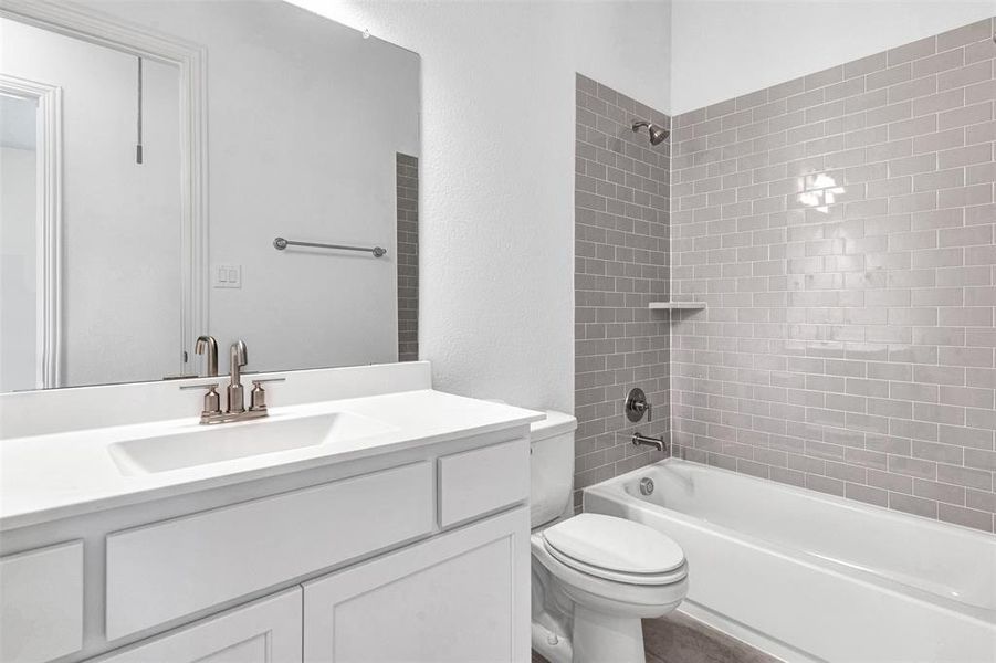 Second bathroom with vanity, tiled shower / bath combo, and toilet