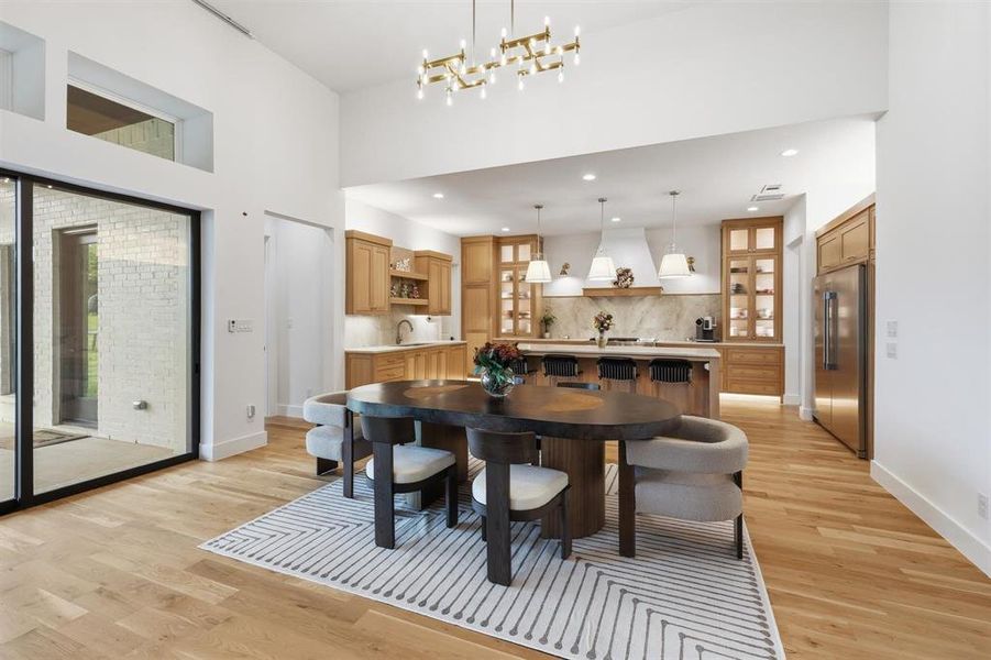 Dining area with light wood-type flooring and a chandelier