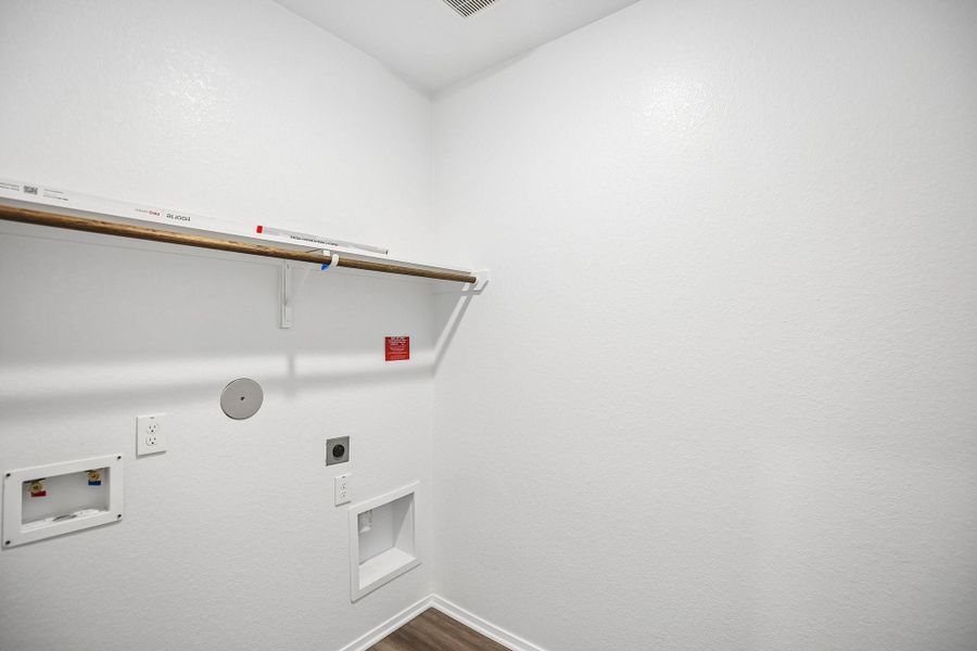 Located just off the main living areas for easy access, the space offers dedicated hookups for a full-size washer and dryer along with room for additional storage solutions.
