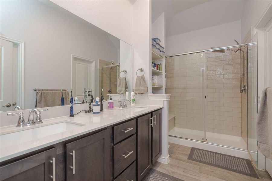 Bathroom with hardwood / wood-style floors, vanity, and a shower with shower door