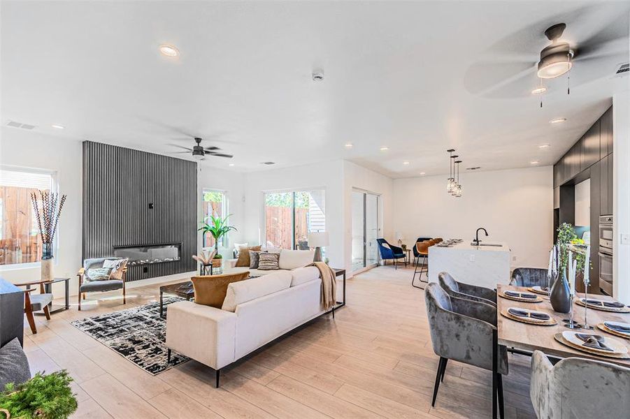 Living area featuring a ceiling fan, recessed lighting, and light wood-type flooring Living area featuring a ceiling fan, recessed lighting, and light wood-type flooring