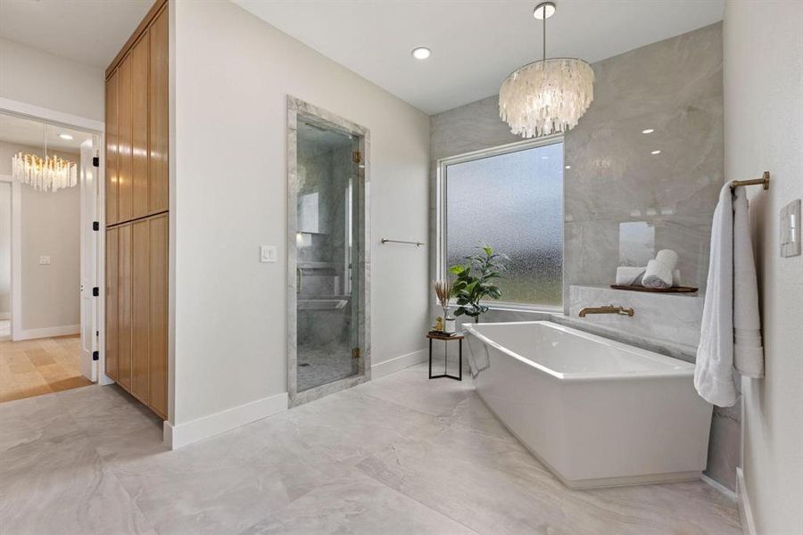 Bathroom with a chandelier, a soaking tub, a stall
shower, and recessed lighting Bathroom with a chandelier, a soaking tub, a stall
shower, and recessed lighting