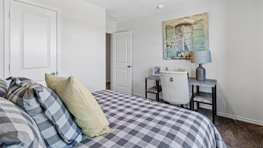 Bedroom with baseboards and dark colored carpet