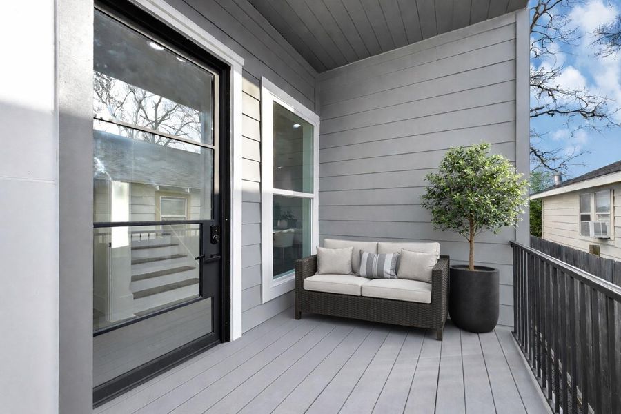 Covered entry balcony featuring a modern glass front door