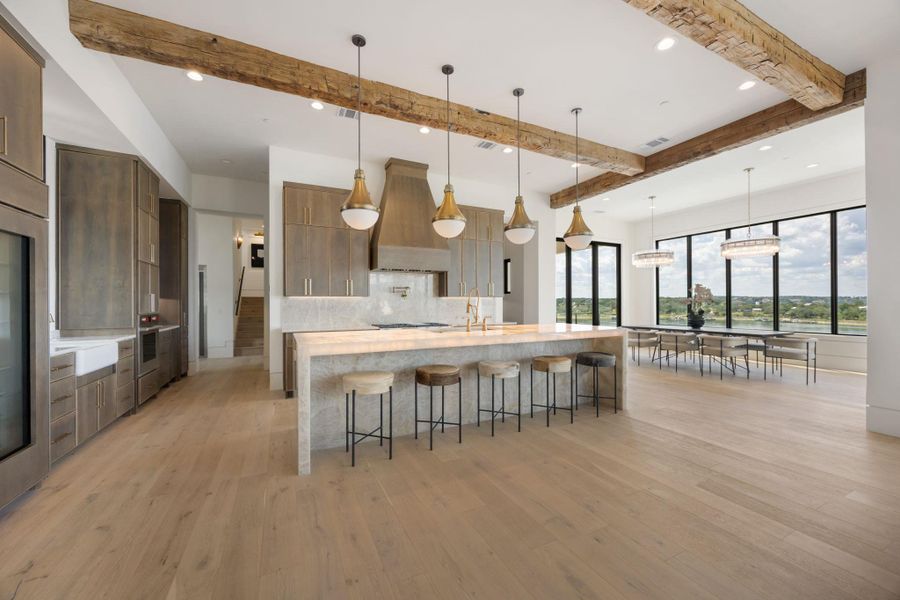 Exposed wood beams crown this gourmet kitchen with a grand island and a dining area, all overlooking tranquil waters. Exposed wood beams crown this gourmet kitchen with a grand island and a dining area, all overlooking tranquil waters.