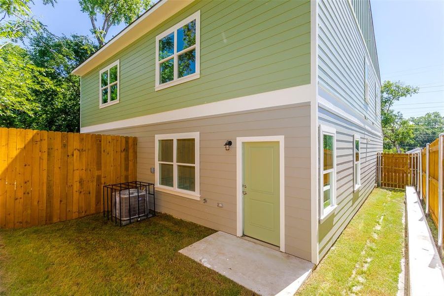 Back of property featuring central air condition unit and a yard