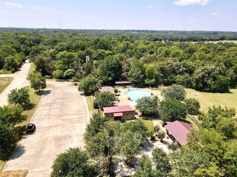 Aerial perspective showcasing a large concrete pad, surrounded by mature trees