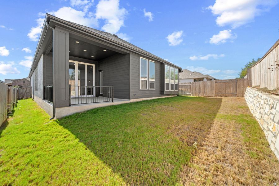 Rear view of house featuring a patio area and a fenced backyard