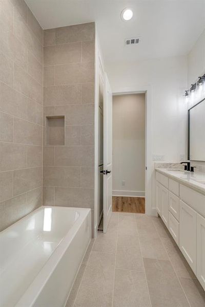 Bathroom with vanity, a bathtub, and tile patterned floors