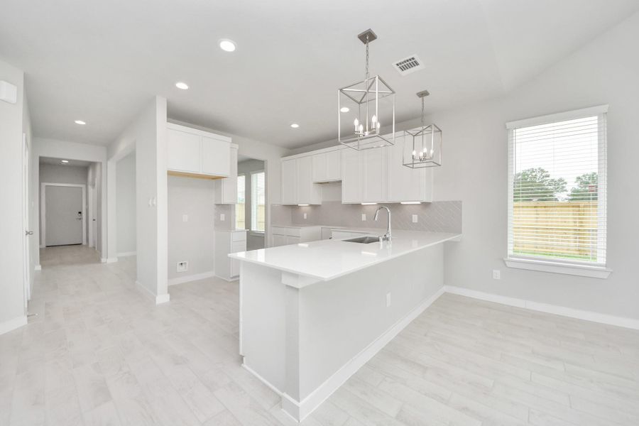 This kitchen is truly a chef's dream! This haven Boasts high ceilings, recessed & pendant lighting, stained wood cabinets, granite countertops, stainless steel appliances, a modern tile backsplash. All of this overlooks your expansive family room, creating a perfect space for culinary delights and family gatherings. Sample photo of completed home with similar floor plan. Actual colors and selections may vary. This kitchen is truly a chef's dream! This haven Boasts high ceilings, recessed & pendant lighting, stained wood cabinets, granite countertops, stainless steel appliances, a modern tile backsplash. All of this overlooks your expansive family room, creating a perfect space for culinary delights and family gatherings. Sample photo of completed home with similar floor plan. Actual colors and selections may vary.