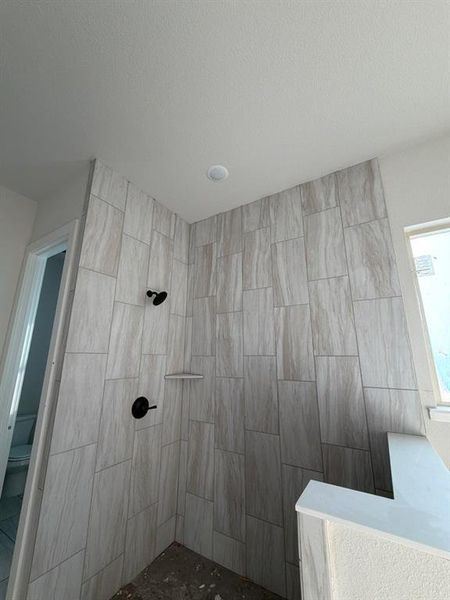 Bathroom with a walk in shower and a textured ceiling