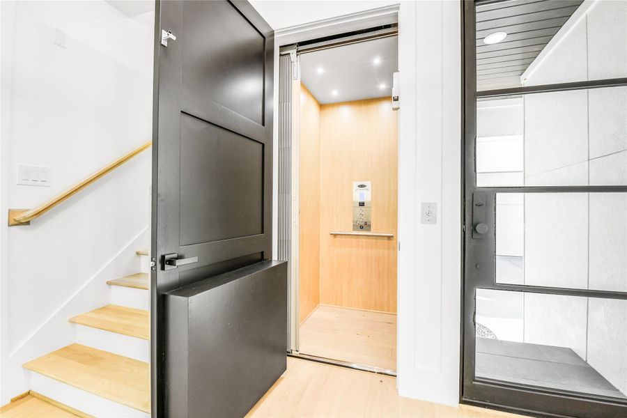 Elevator READY - This is photo from 1907 - Luxury meets functionality with a private in-home elevator—perfect for multi-level living and easy access to every floor. The space is defined by sleek black doors, natural wood accents, and clean architectural lines. The adjacent staircase features white risers and light oak treads, showcasing meticulous craftsmanship and contemporary design continuity from the foyer throughout the home. Elevator READY - This is photo from 1907 - Luxury meets functionality with a private in-home elevator—perfect for multi-level living and easy access to every floor. The space is defined by sleek black doors, natural wood accents, and clean architectural lines. The adjacent staircase features white risers and light oak treads, showcasing meticulous craftsmanship and contemporary design continuity from the foyer throughout the home.