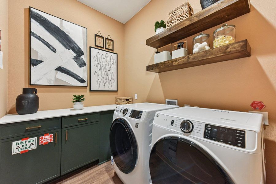 Functional workspace highlights custom green cabinetry beneath clean white countertops.