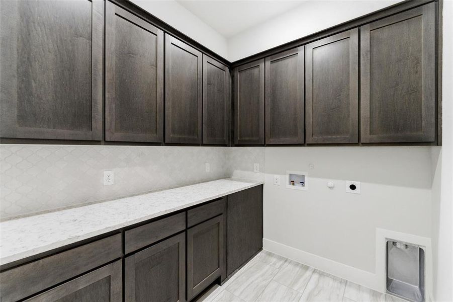 Washroom featuring hookup for a gas dryer, hookup for a washing machine, cabinet space, and hookup for an electric dryer