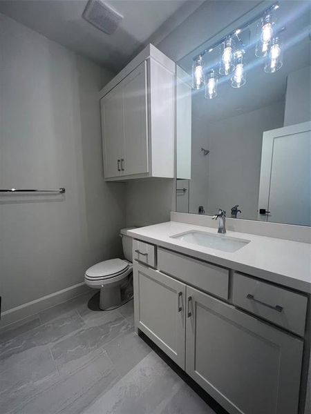 Bathroom featuring tile flooring, vanity, and toilet